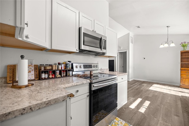 9 Juniper Pass Trl, Ocala, FL 34480 - kitchen with appliances with stainless steel finishes, white cabinets, a chandelier, wood finished floors, and pendant lighting