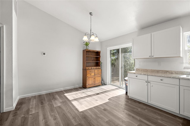 9 Juniper Pass Trl, Ocala, FL 34480 - unfurnished dining area featuring wood finished floors, vaulted ceiling, a chandelier, and baseboards