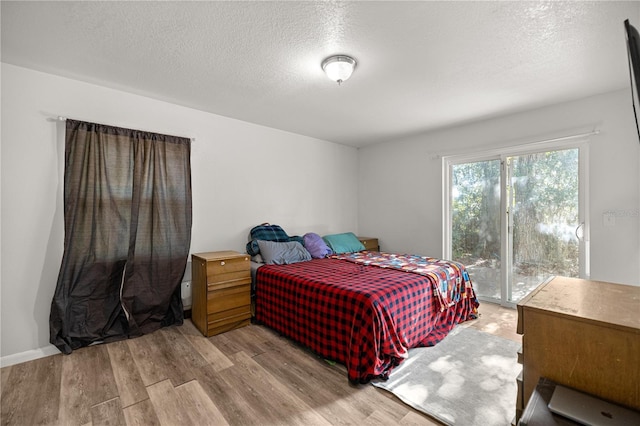 9 Juniper Pass Trl, Ocala, FL 34480 - bedroom with wood finished floors, access to exterior, and a textured ceiling