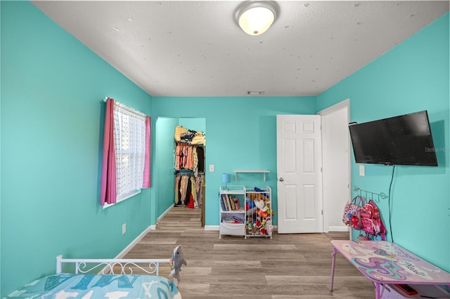 9 Juniper Pass Trl, Ocala, FL 34480 - bedroom featuring wood finished floors, a spacious closet, baseboards, and a closet