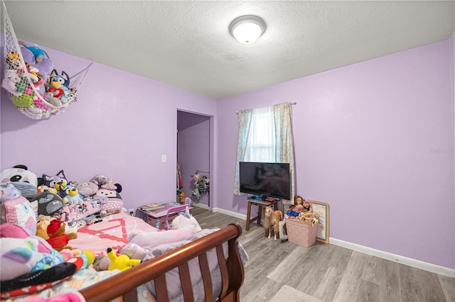 9 Juniper Pass Trl, Ocala, FL 34480 - bedroom with light wood finished floors, a textured ceiling, and baseboards