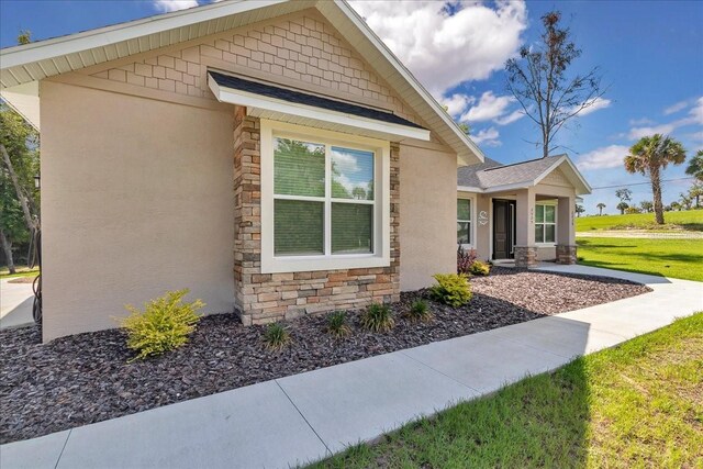 view of side of home with stone siding and stucco siding