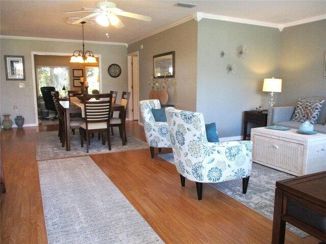 13762 SW 112th Ter, Dunnellon, FL 34432 - living room featuring wood finished floors, ceiling fan, ornamental molding, a chandelier, and baseboards