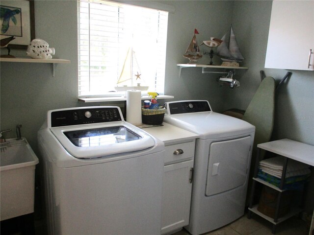 13762 SW 112th Ter, Dunnellon, FL 34432 - laundry area with washer and clothes dryer, healthy amount of natural light, cabinet space, and light tile patterned floors
