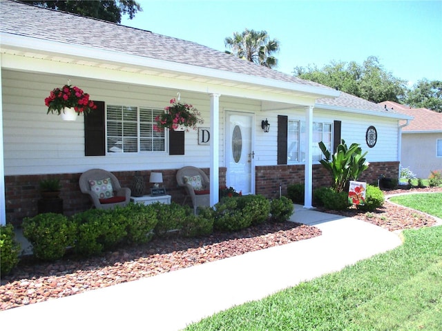 13762 SW 112th Ter, Dunnellon, FL 34432 - view of front of property featuring brick siding, a shingled roof, and covered porch