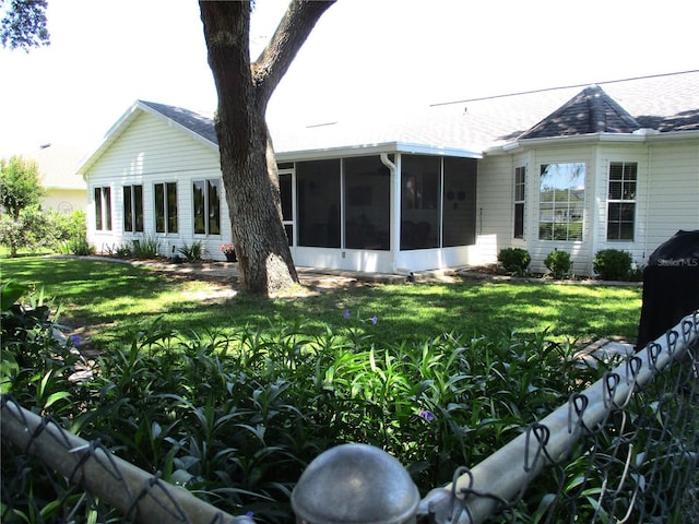 13762 SW 112th Ter, Dunnellon, FL 34432 - rear view of property featuring a sunroom, a yard, and roof with shingles