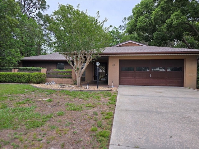 ranch-style home with stucco siding, driveway, and a garage