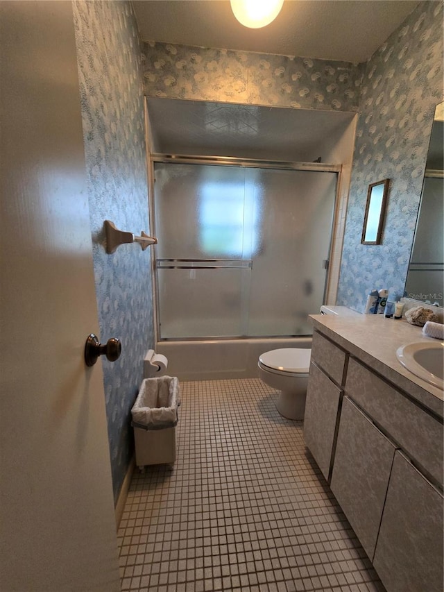bathroom featuring wallpapered walls, toilet, shower / bath combination with glass door, vanity, and tile patterned flooring