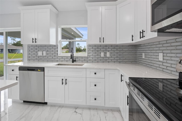 3079 SW 168th Loop, Ocala, FL 34473 - kitchen with stainless steel appliances, light marble finish flooring, white cabinets, tasteful backsplash, and light stone counters