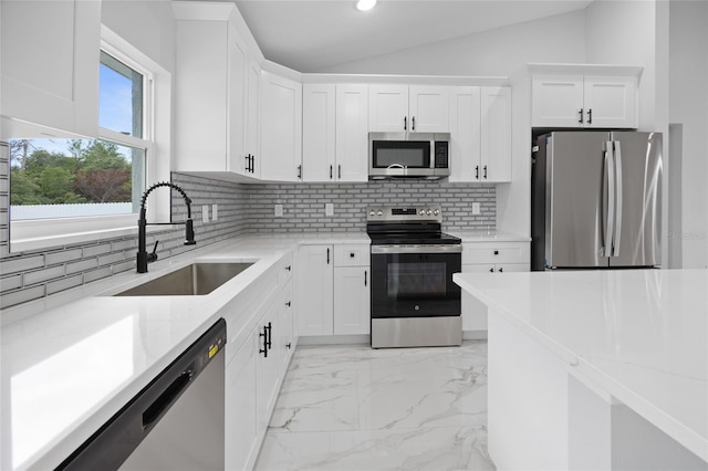 3079 SW 168th Loop, Ocala, FL 34473 - kitchen featuring appliances with stainless steel finishes, decorative backsplash, white cabinets, vaulted ceiling, and recessed lighting