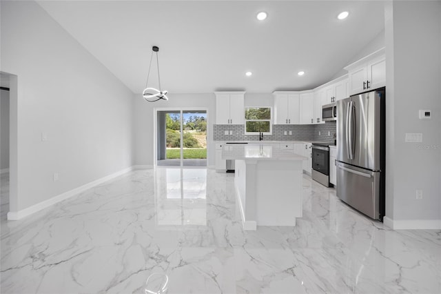 3079 SW 168th Loop, Ocala, FL 34473 - kitchen featuring stainless steel appliances, vaulted ceiling, light marble finish flooring, tasteful backsplash, and white cabinets