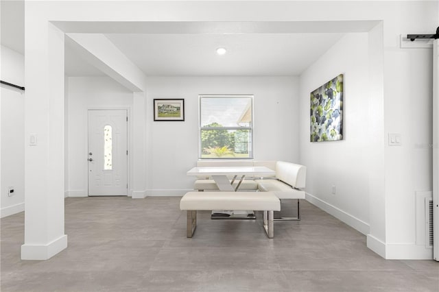 10291 SE 67th Ter, Belleview, FL 34420 - living area with a barn door, concrete floors, and baseboards