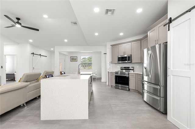 10291 SE 67th Ter, Belleview, FL 34420 - kitchen with a barn door, appliances with stainless steel finishes, gray cabinetry, open floor plan, and a sink