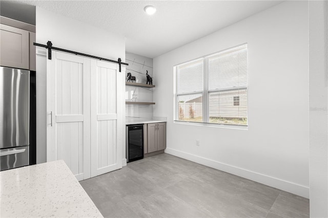 10291 SE 67th Ter, Belleview, FL 34420 - kitchen featuring freestanding refrigerator, beverage cooler, a barn door, baseboards, and open shelves