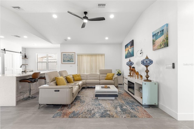10291 SE 67th Ter, Belleview, FL 34420 - living room featuring a ceiling fan, recessed lighting, concrete flooring, a barn door, and baseboards