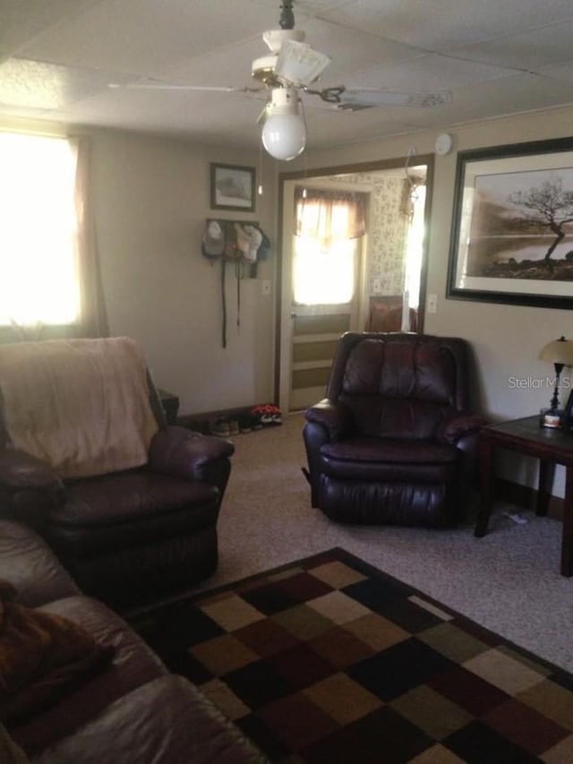carpeted living room featuring ceiling fan
