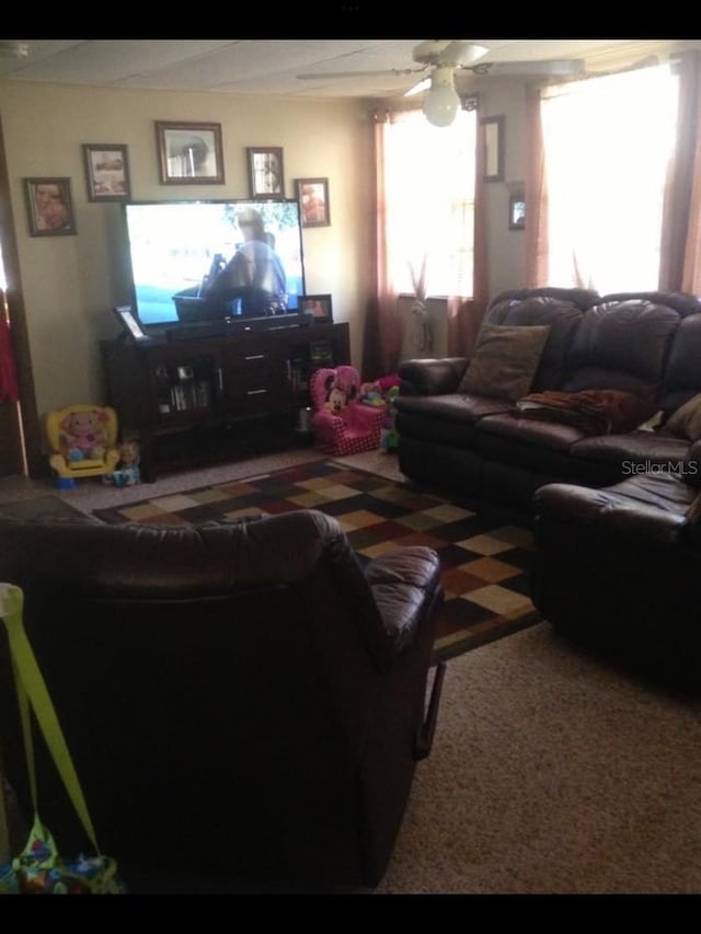 living room with a ceiling fan and carpet flooring