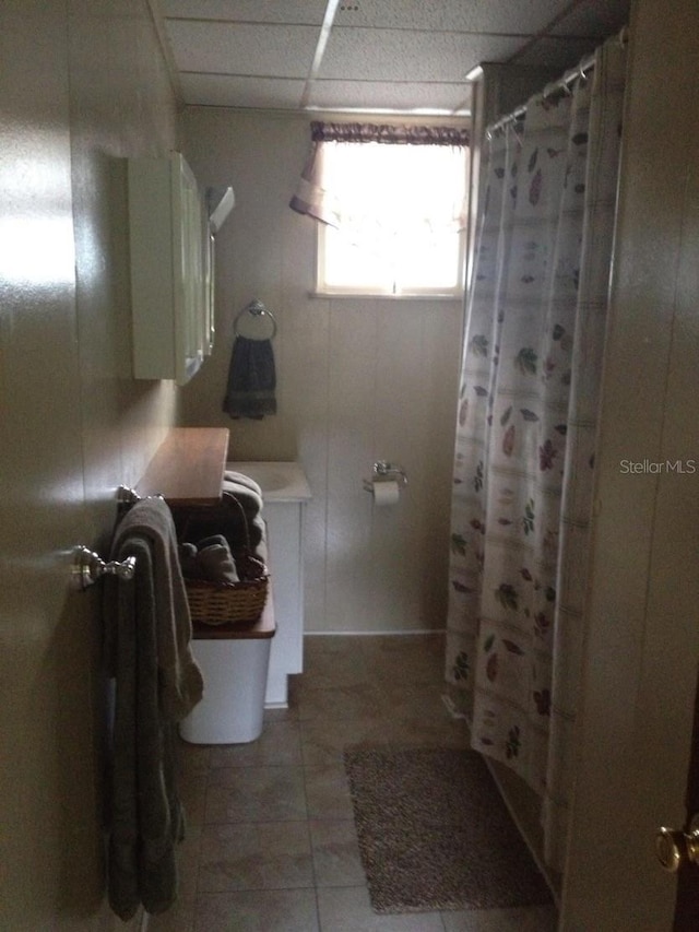 bathroom featuring tile patterned floors, curtained shower, and a paneled ceiling