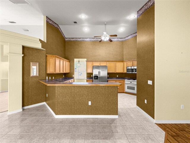 28 Golf View Dr, Ocala, FL 34472 - kitchen with appliances with stainless steel finishes, a peninsula, a high ceiling, ceiling fan, and light tile patterned floors