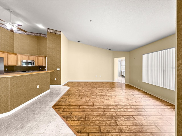 28 Golf View Dr, Ocala, FL 34472 - unfurnished living room featuring ceiling fan, vaulted ceiling, and baseboards