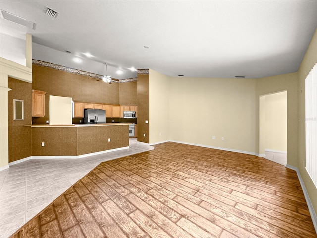 28 Golf View Dr, Ocala, FL 34472 - kitchen with stainless steel appliances, open floor plan, a ceiling fan, a high ceiling, and a peninsula