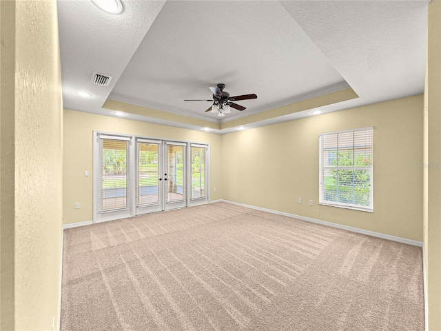 28 Golf View Dr, Ocala, FL 34472 - empty room featuring a tray ceiling, ornamental molding, carpet floors, healthy amount of natural light, and a ceiling fan