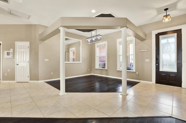 tiled entryway featuring decorative columns and baseboards