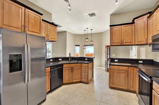 kitchen with appliances with stainless steel finishes, a sink, a peninsula, and track lighting