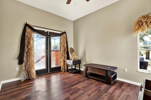 living area with plenty of natural light, wood finished floors, a ceiling fan, and baseboards
