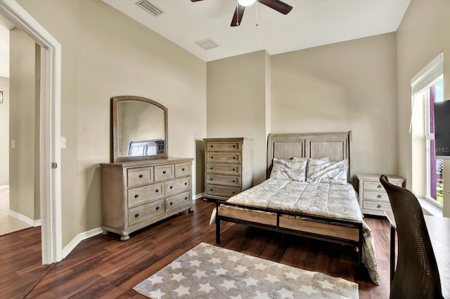 bedroom featuring dark wood finished floors, baseboards, vaulted ceiling, and a ceiling fan