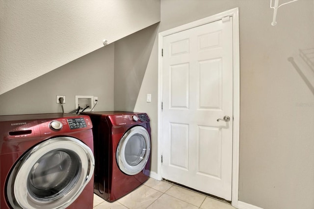 clothes washing area featuring washing machine and clothes dryer, baseboards, and light tile patterned flooring