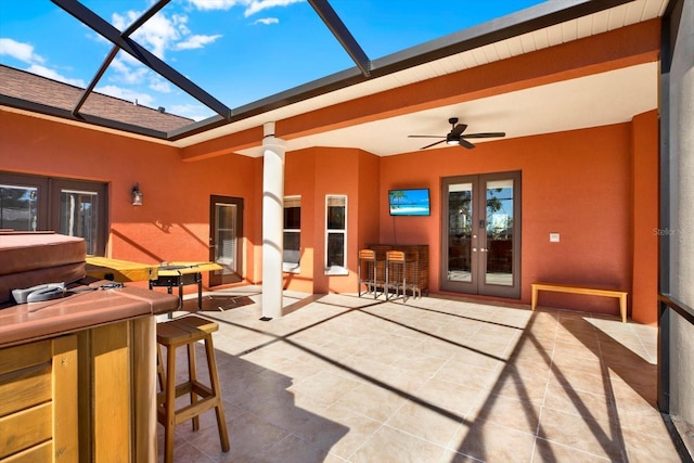 view of patio / terrace with french doors, a ceiling fan, and glass enclosure