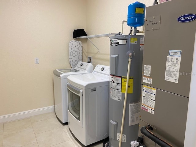 laundry room featuring electric water heater, washer and clothes dryer, heating unit, baseboards, and light tile patterned flooring