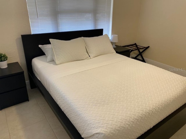 bedroom featuring light tile patterned floors and baseboards