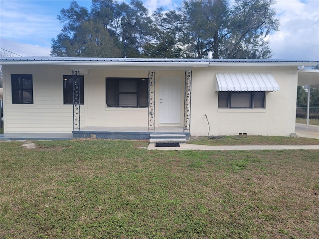 bungalow-style house featuring a front yard, metal roof, and a carport