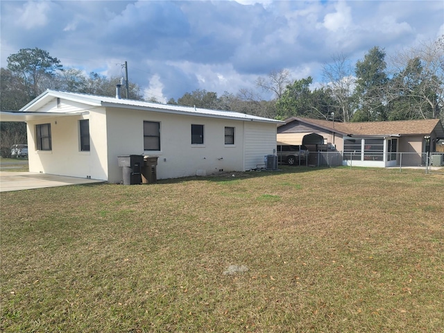 back of property with central air condition unit, stucco siding, metal roof, and a carport
