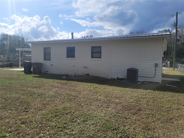 view of side of home with central AC unit and metal roof