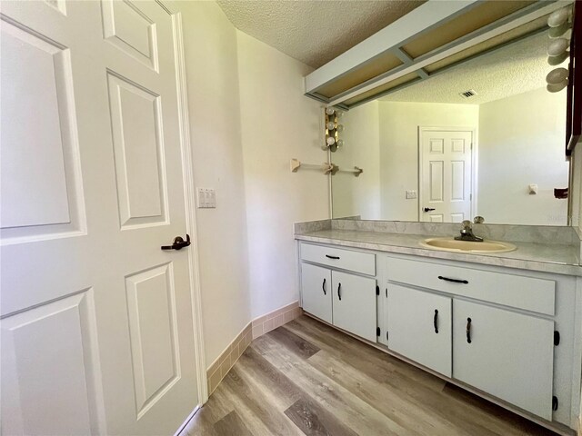 8239 SW 108th St, Ocala, FL 34481 - bathroom featuring vanity, a textured ceiling, wood finished floors, and baseboards