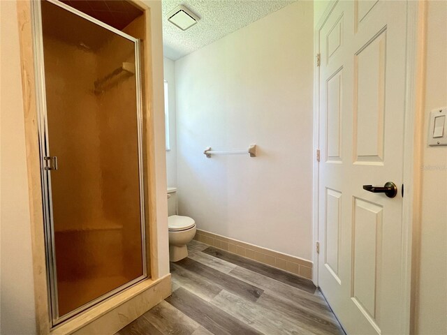 8239 SW 108th St, Ocala, FL 34481 - full bathroom featuring a textured ceiling, a shower stall, wood finished floors, toilet, and baseboards
