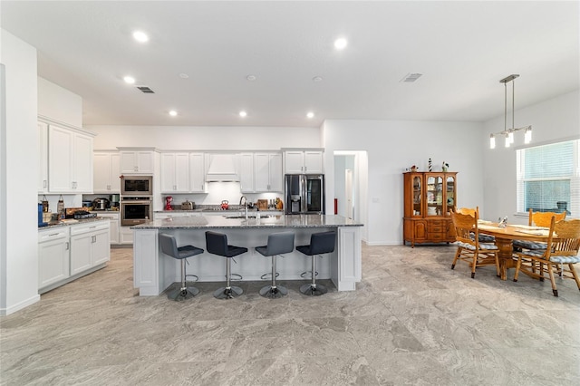 6046 SW 86th Cir, Ocala, FL 34481 - kitchen featuring stainless steel appliances, custom range hood, an island with sink, a kitchen bar, and white cabinetry