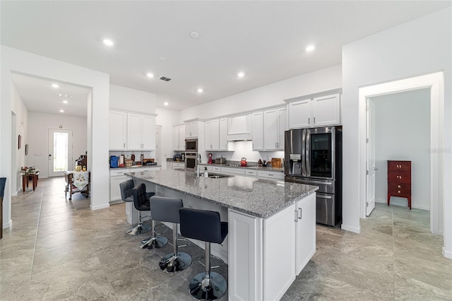 6046 SW 86th Cir, Ocala, FL 34481 - kitchen featuring appliances with stainless steel finishes, a large island, white cabinetry, a kitchen breakfast bar, and light stone countertops
