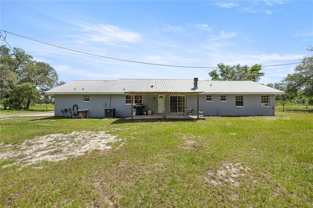 20818 SW 119th Ave, Archer, FL 32618 - back of house with central air condition unit, a yard, and metal roof