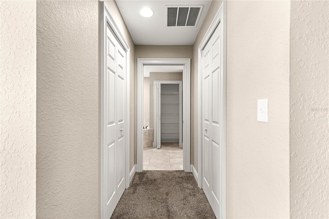 10313 SW 45th Ave, Ocala, FL 34476 - corridor with a textured wall, dark carpet, and baseboards