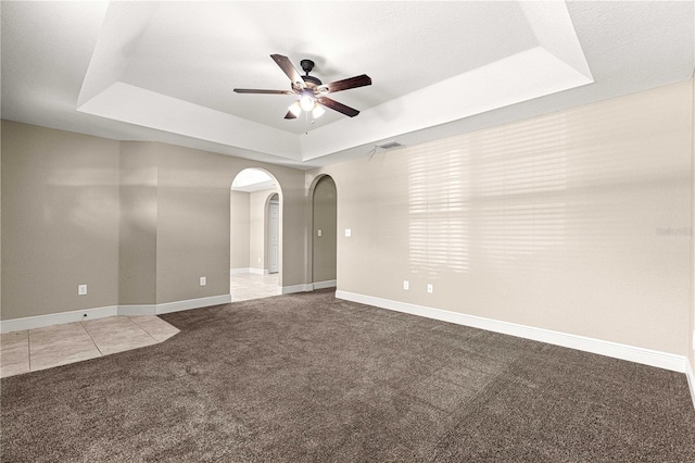 10313 SW 45th Ave, Ocala, FL 34476 - carpeted spare room featuring a raised ceiling, ceiling fan, arched walkways, and baseboards