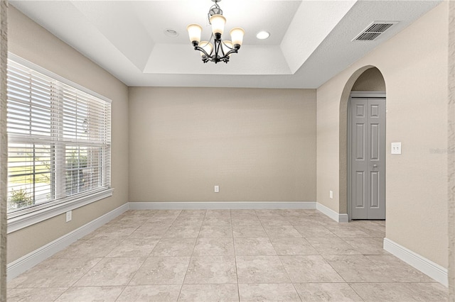 10313 SW 45th Ave, Ocala, FL 34476 - empty room with a chandelier, arched walkways, a raised ceiling, and light tile patterned floors