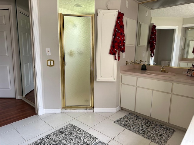 bathroom with tile patterned floors, a stall shower, and baseboards