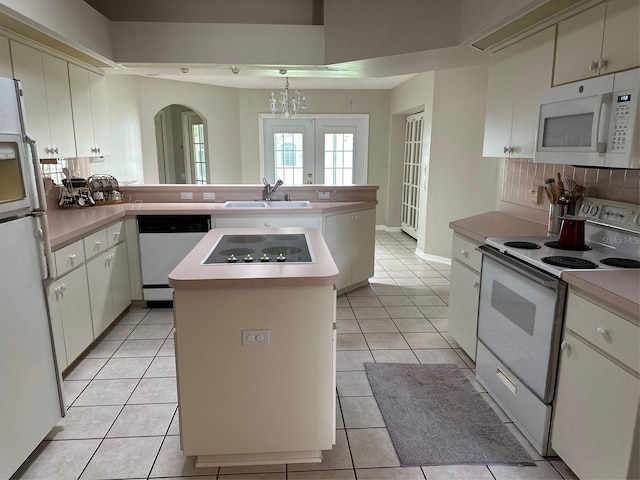 kitchen with white appliances, a sink, and light countertops