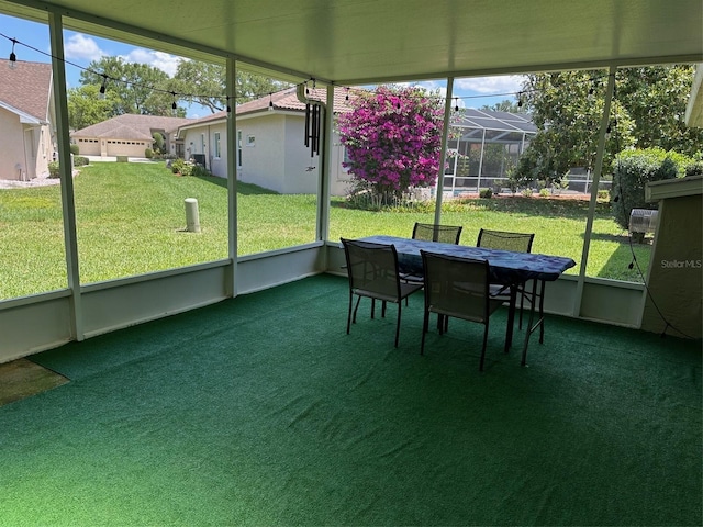 sunroom featuring healthy amount of natural light, outdoor dining space, and a residential view