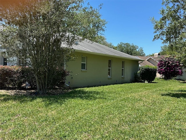 view of property exterior featuring stucco siding and a yard