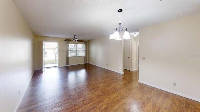 spare room featuring ceiling fan, a chandelier, wood finished floors, baseboards, and a textured ceiling